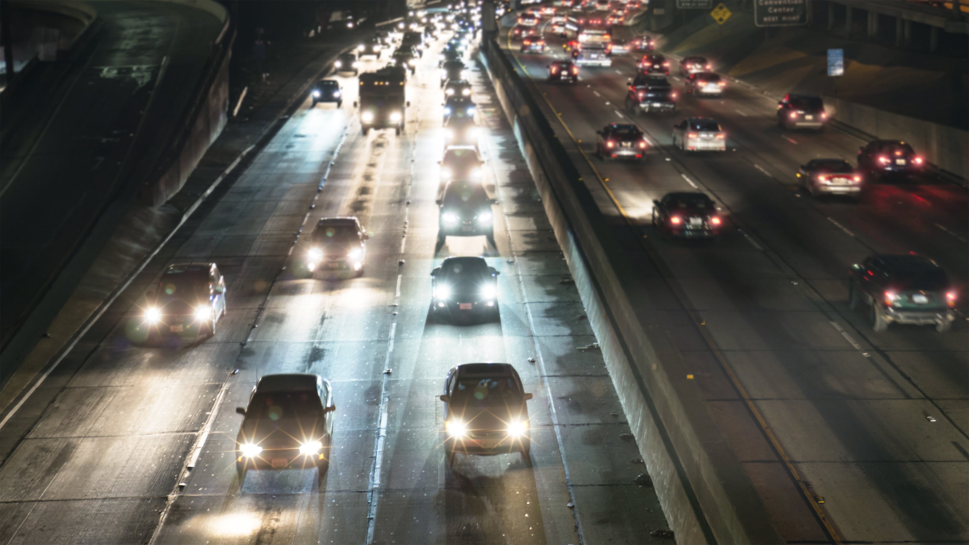 Heavy traffic on a highway at night with multiple cars and bright headlights. Image illustrates different effect of lenses.
