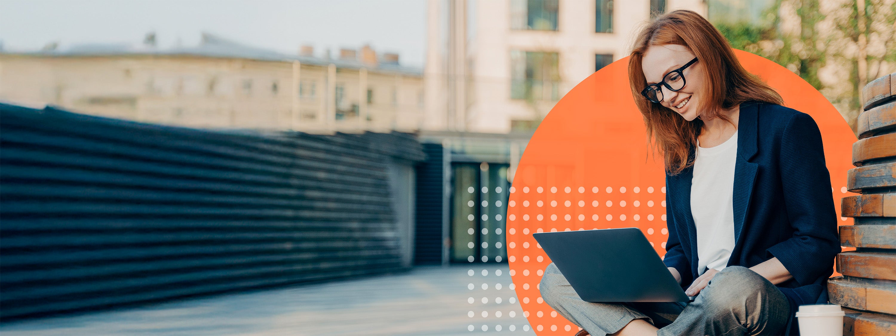 Woman using a laptop on a rooftop with a blurred background