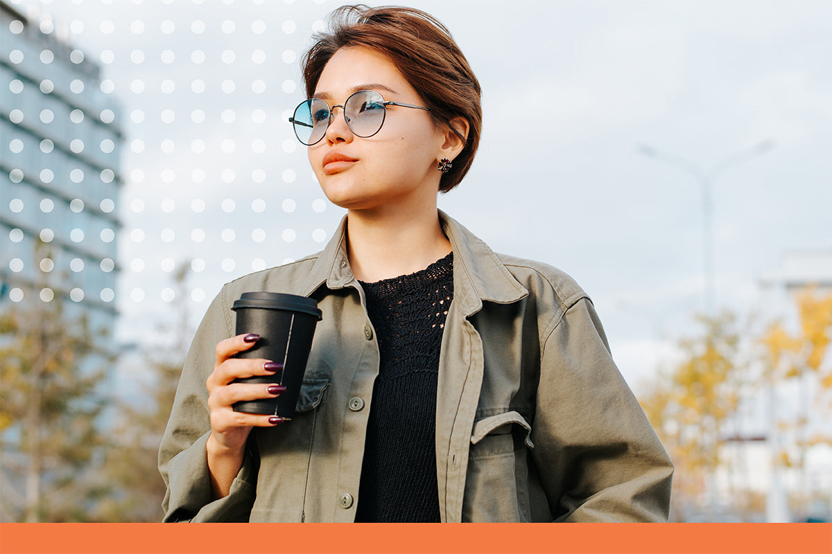 Woman holding a coffee cup outdoors with blurred background