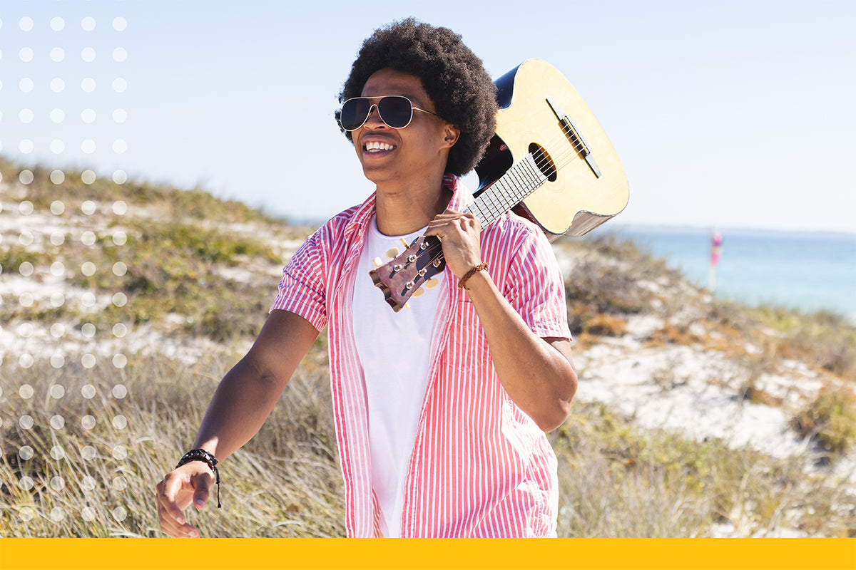 Person holding a guitar on a scenic background