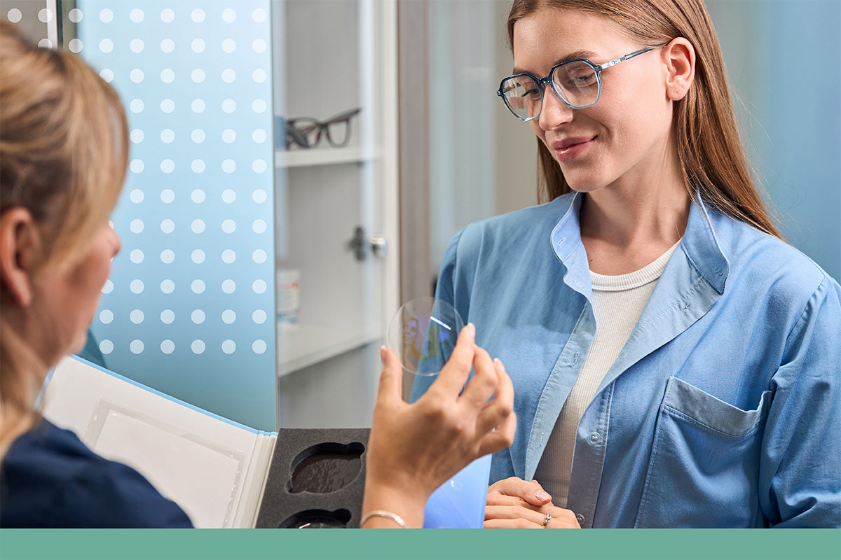 Doctor in a blue coat explaining something to a patient in a medical setting.