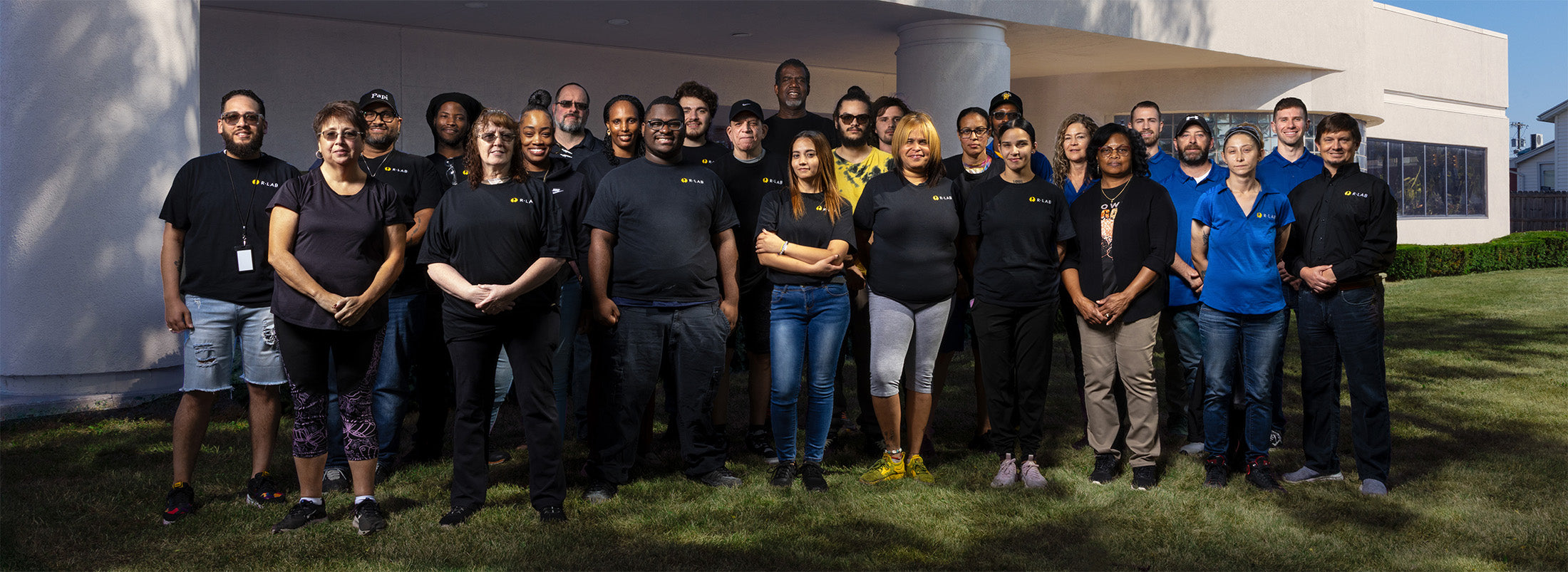 The team from Rlab posing for a photo in front of a modern building.