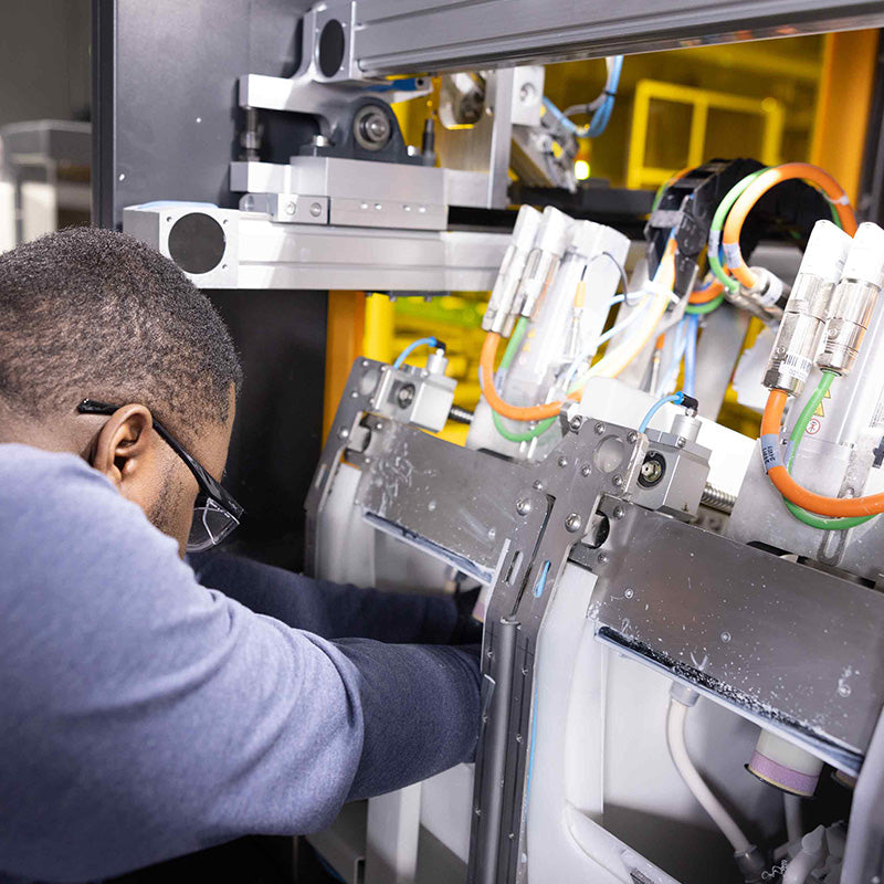 Person working on a machine with intricate components