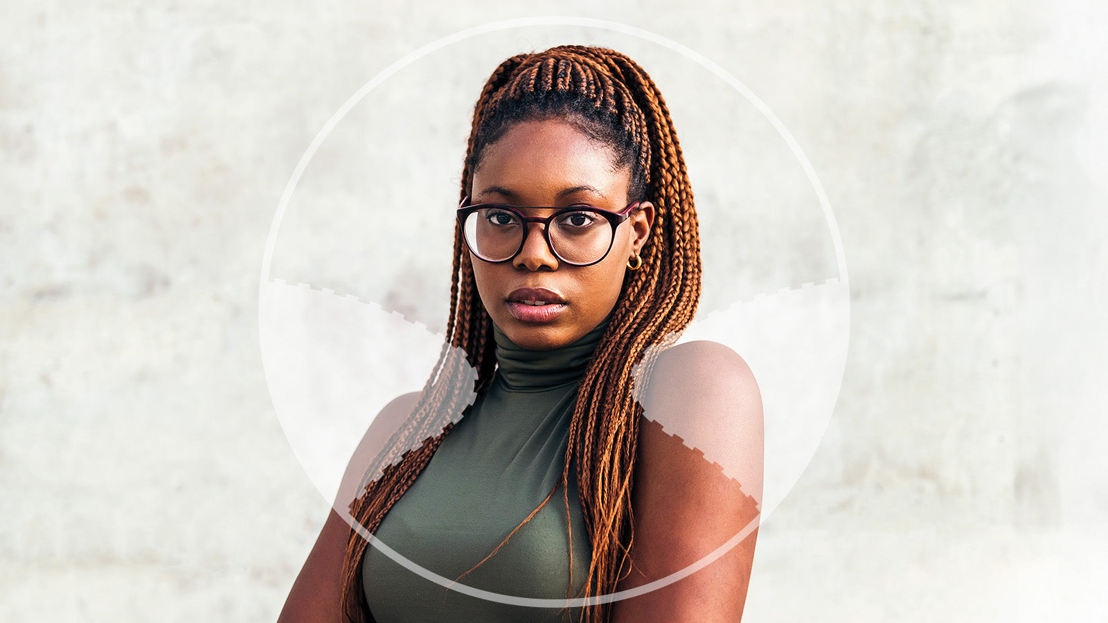 Woman with braided hair wearing glasses against a light background