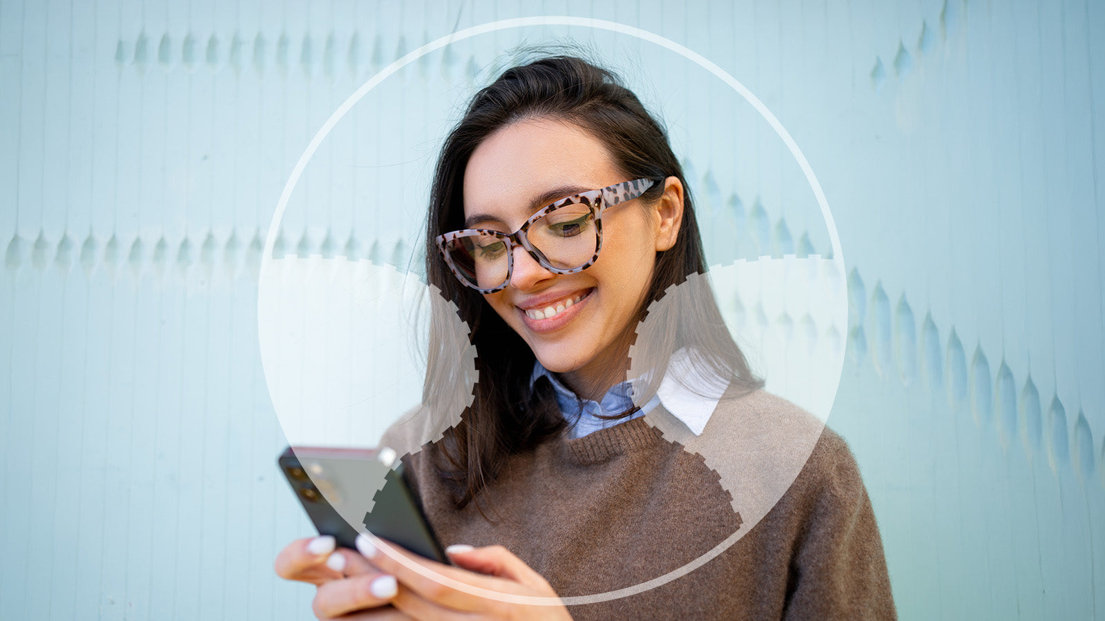 Woman wearing glasses and holding a phone with a light blue background