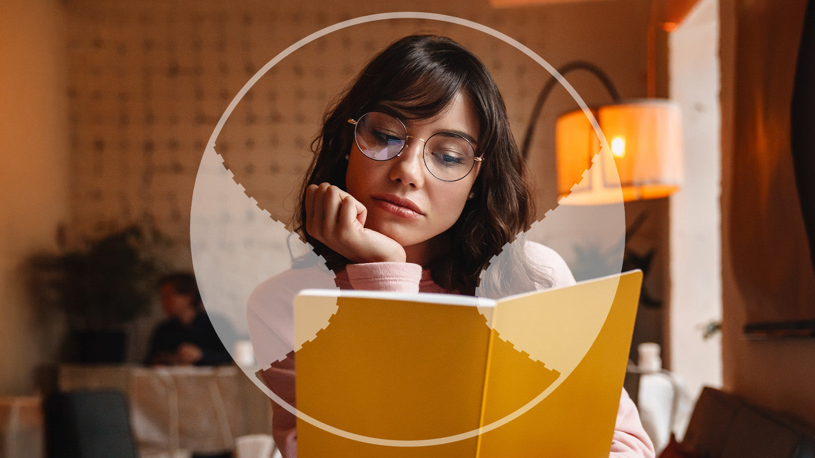 Woman reading a yellow book in a cozy indoor setting